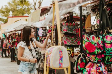 meksika sokaklarında geleneksel Meksika pazarında hediyelik eşya satın gezgin kız, açık Latin Amerika'da duran İspanyol turistler