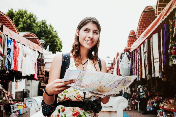 Mochilera latina con mapa en un mercado turístico de la Ciudad de México, viajera mexicana en América — Foto de Stock
