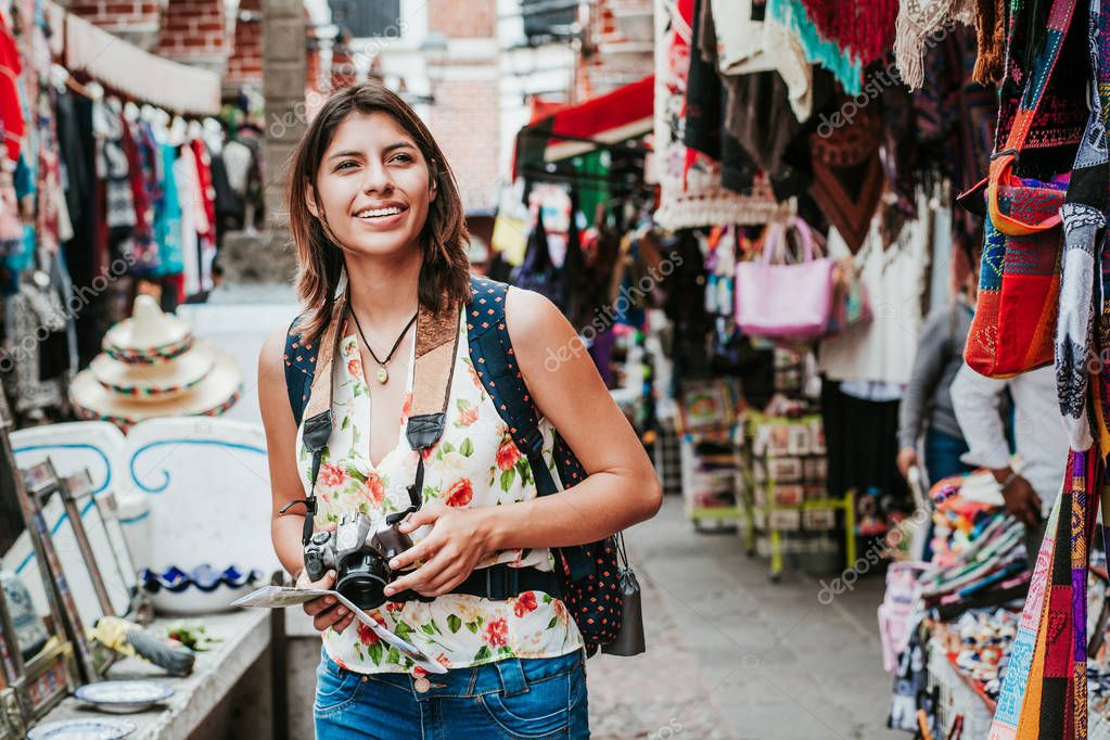 Mochilera latina comprando en un mercado turístico en la Ciudad de