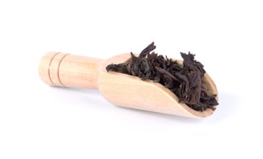 Siyah çay yaprakları ahşap Kepçe beyaz arka plan üzerinde izole içinde kurutulmuş