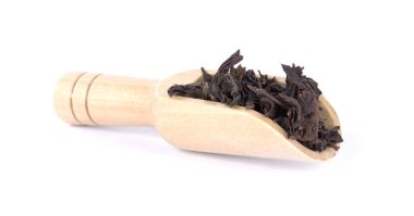 Siyah çay yaprakları ahşap Kepçe beyaz arka plan üzerinde izole içinde kurutulmuş