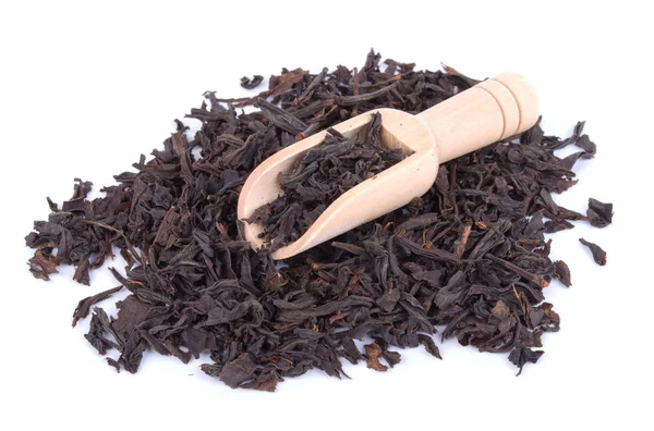Черный чай сушеные листья в деревянной сенсации изолированы на белом фоне — стоковое фото