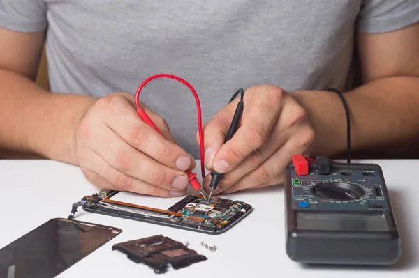 Repairman fixing disassembled smartphone with special tools. concept of electronics repair devices