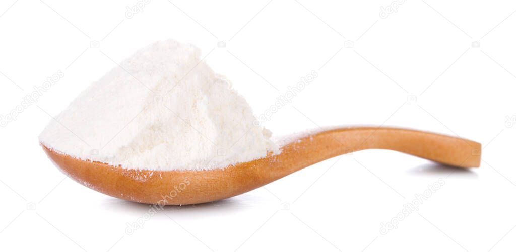 Wheat flour in wooden spoon on white background