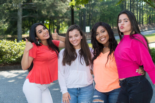 Группа молодых подруг проводит время вместе на улице
