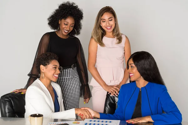 Group of four minority businesswomen working together in the office