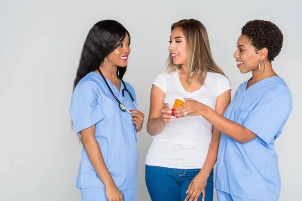 Two african american nurses working with a patient at the hospital