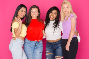 Pembe bir arka plan üzerinde birlikte eğleniyor dört genç kız Grup