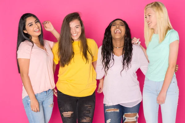 stock image Group of four teen girls having fun together on a pink background