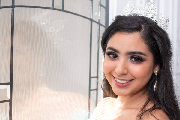 Young teen hispanic girl wearing a quinceanera dress