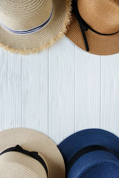 Straw hats with ribbon and bow on white background. Set of beach hats, summer accessory, close up, top view, copy space. Travel, sale concept