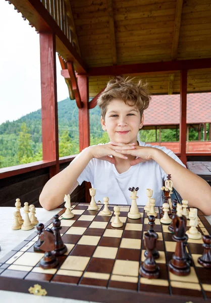 smart, cute, young boy is thinking about a move on the  chessboard.Education concept, chess lesson,  intellectual game