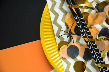 Cadılar Bayramı partisi konsepti dekoratif konfeti, kaplamalar ve renkli arka plan üzerinde siyah süslü saman ile düz yatıyordu stili. Üstten görünüm