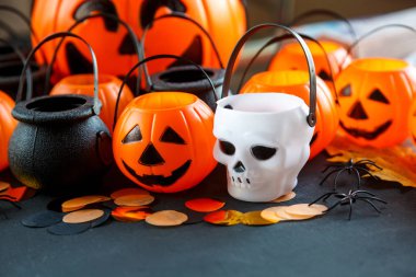 Halloween süslemeleri. Dekoratif Turuncu kabak, kazanlarda, kafatasları siyah arka plan üzerine. Cadılar Bayramı kavramı. 