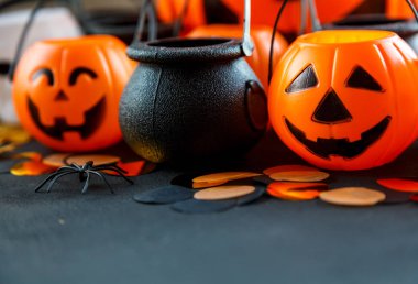 Halloween süslemeleri. Dekoratif Turuncu kabak, kazanlarda, kafatasları siyah arka plan üzerine. Cadılar Bayramı kavramı. 