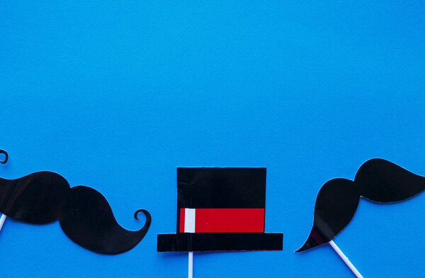 Moustache photo booth props on blue background. Moustache cut outs. Movember Movement. Prostate Cancer Awareness, Men's health awareness concept. flat lay, top view, copyspace