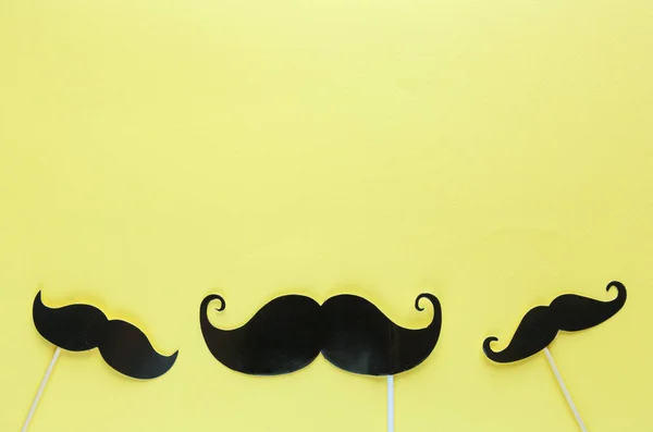 在黄色背景上的小胡子照片摊位道具 胡子剪掉了 Movember 前列腺癌意识 男性健康意识的概念 顶部视图 Copyspace — 图库照片