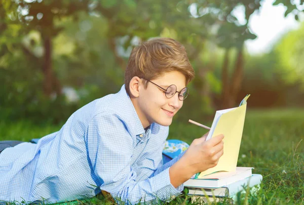 Carino Ragazzo Occhiali Rotondi Camicia Blu Legge Libro Sdraiato Sull — Foto Stock