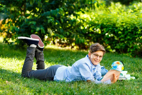 Carino Ragazzo Occhiali Rotondi Camicia Blu Legge Libro Sdraiato Sull — Foto Stock