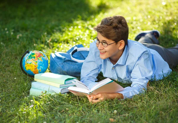 Carino Ragazzo Occhiali Rotondi Camicia Blu Legge Libro Sdraiato Sull — Foto Stock