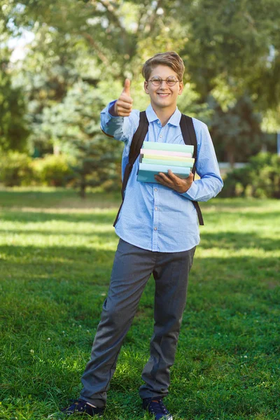 小男孩在圆杯子 蓝色衬衣与背包存放书 回归学校理念 — 图库照片
