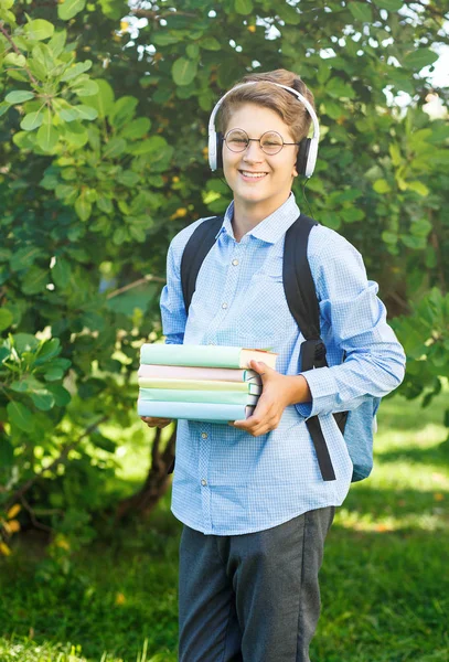 小男孩在圆杯子 蓝色衬衣与背包存放书 回归学校理念 — 图库照片