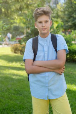 Sevimli, zeki, Genç çocuk mavili çocuğa yaz aylarında çimlere park üzerinde duruyor. Okul hazırlıkları, eğitim kavramı