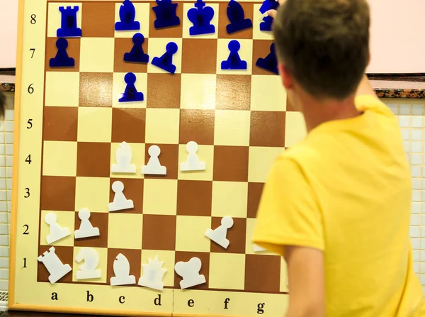 小男孩在想在磁铁板上移动一下 教育观念 国际象棋课 智力游戏 — 图库照片