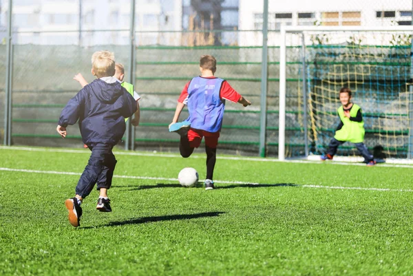 身穿红蓝绿制服的男孩子们在绿草上踢足球 团队游戏 积极的生活方式 体育为孩子的概念 — 图库照片
