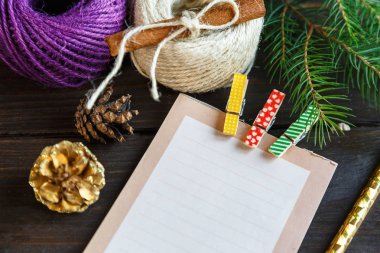 arkadaşlarınız ve aileniz için bir şeyler yapmak için liste veya hediye listesi yapmak için ahşap arka plan üzerinde not defteri bırakır. Yeni yıl ve Noel kavramı