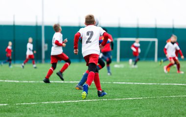 futbol takımları - kırmızı, mavi, Beyaz üniformalı erkekler yeşil sahada futbol oynamak. Çocuklar top sürme. top sürme becerileri. Takım oyunu, eğitim, aktif yaşam tarzı, hobi, spor çocuklar konsepti için