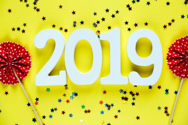Beyaz ahşap numaraları 2019 sarı zemin üzerine kırmızı hayranları ile. Yaratıcı Noel ve yeni yıl arka plan