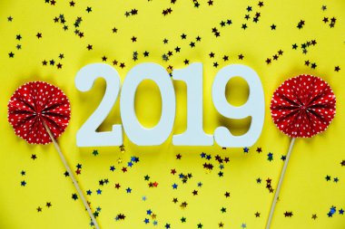 Beyaz ahşap numaraları 2019 sarı zemin üzerine kırmızı hayranları ile. Yaratıcı Noel ve yeni yıl arka plan