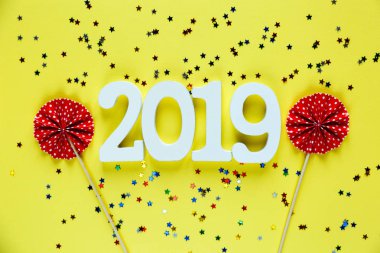 Beyaz ahşap numaraları 2019 sarı zemin üzerine kırmızı hayranları ile. Yaratıcı Noel ve yeni yıl arka plan