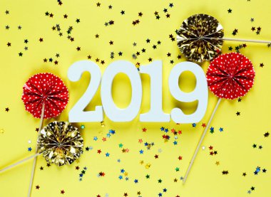 Beyaz ahşap numaraları 2019 sarı zemin üzerine kırmızı ve altın hayranları ile. Yaratıcı Noel ve yeni yıl arka plan