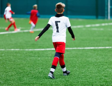 futbol takımları - kırmızı, mavi, Beyaz üniformalı erkekler yeşil sahada futbol oynamak. Çocuklar top sürme. top sürme becerileri. Takım oyunu, eğitim, aktif yaşam tarzı, hobi, spor çocuklar konsepti için