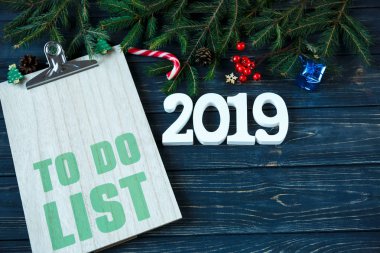 Ahşap tablası üzerinde listelemek için sayıları 2019 ve köknar ağacın, gri ahşap masa dekor beyaz. Listesi yeni yıl gol, Noel kavramı üzerinde yapmam gerekenler. düz lay ile boşaltmak.