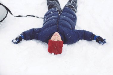 Çocuk mavi ceket ve kar tüp kırmızı şapka. Çocuk bir boru sürme. Kış eğlence, etkinlikler. aktif spor, yaşam biçimi