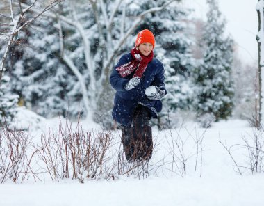 mavi ceketli genç yakışıklı kartopu Kış Parkı'nda oynar. Kış aktiviteleri. 