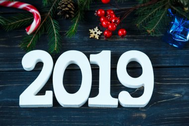 Beyaz ahşap sayılarla 2019 dekor, Ladin ağacı dalları gri ahşap masa üzerinde. Yeni yıl ve Noel dekorasyon konsepti