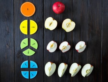 colorful math fractions and apples as a sample on brown wooden background or table. interesting math for kids. Education, back to school concept. Geometry and mathematics materials. clipart