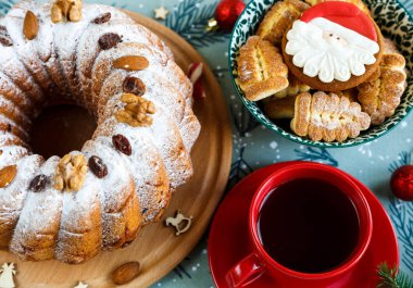 Meyveli kek, dekorasyon, Ladin, bir pasta ve kırmızı fincan kahve ya da çay mavi Amerikan Servisi ile plaka dalları. Yeni yıl ve Noel dekorasyon konsepti. kopya alanı