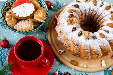 Meyveli kek, dekorasyon, Ladin, bir pasta ve kırmızı fincan kahve ya da çay mavi Amerikan Servisi ile plaka dalları. Yeni yıl ve Noel dekorasyon konsepti. kopya alanı