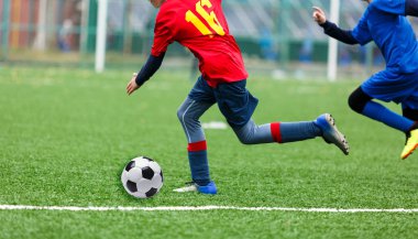 futbol takımları - kırmızı, mavi spor giyim çocuklar yeşil sahada futbol oynamak. Çocuklar top sürme. top sürme becerileri. Takım oyunu, eğitim, aktif yaşam tarzı, hobi, spor çocuklar konsepti için