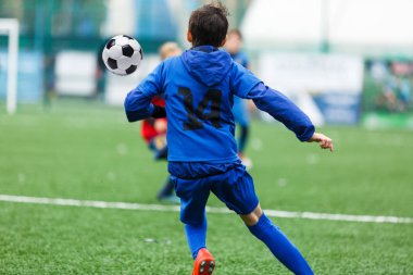 futbol takımları - kırmızı, mavi spor giyim çocuklar yeşil sahada futbol oynamak. Çocuklar top sürme. top sürme becerileri. Takım oyunu, eğitim, aktif yaşam tarzı, hobi, spor çocuklar konsepti için