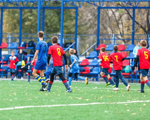 青い赤いスポーツウェアの少年たちは フィールドにサッカー ドリブルボールを果たしている 緑の芝生の上でボールを持つ若いサッカー選手 トレーニング サッカー 子供のためのアクティブなライフスタイルの概念 — ストック写真