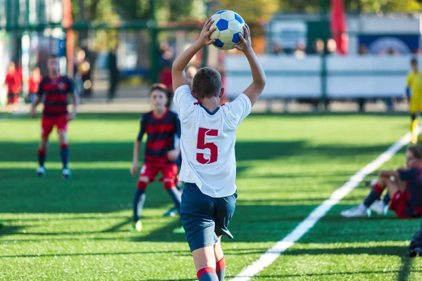 ジュニア サッカーの試合 青と白のスポーツ ウエア サッカーで少年に一致します サッカー スタジアムとバック グラウンドでの草原 — ストック写真