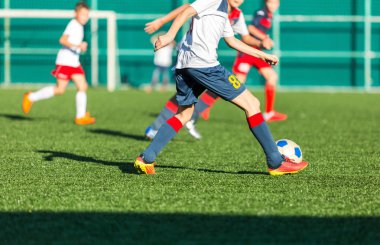 futbol takımları - kırmızı, mavi, beyaz spor giyim çocuklar yeşil sahada futbol oynamak. Çocuklar top sürme. top sürme becerileri. Takım oyunu, eğitim, aktif yaşam tarzı, hobi, spor çocuklar konsepti için