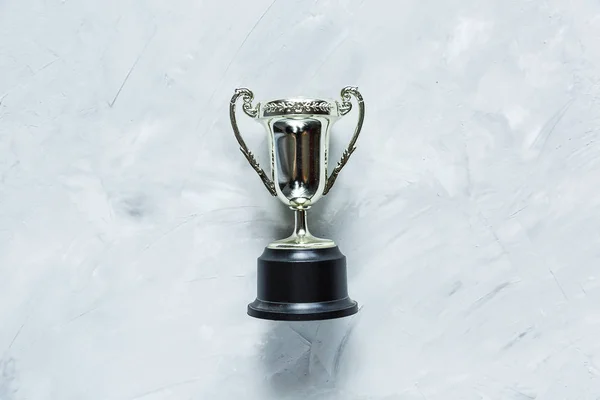Golden trophy on grey cement background. sport achievement, success concept. Gold trophy as a leader. Business successful.
