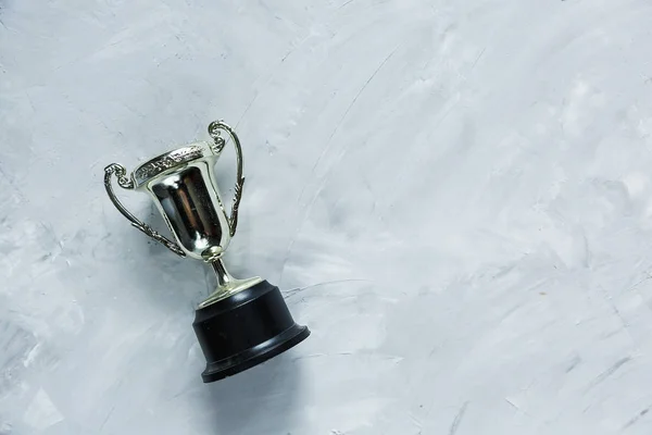 Golden trophy on grey cement background. sport achievement, success concept. Gold trophy as a leader. Business successful.